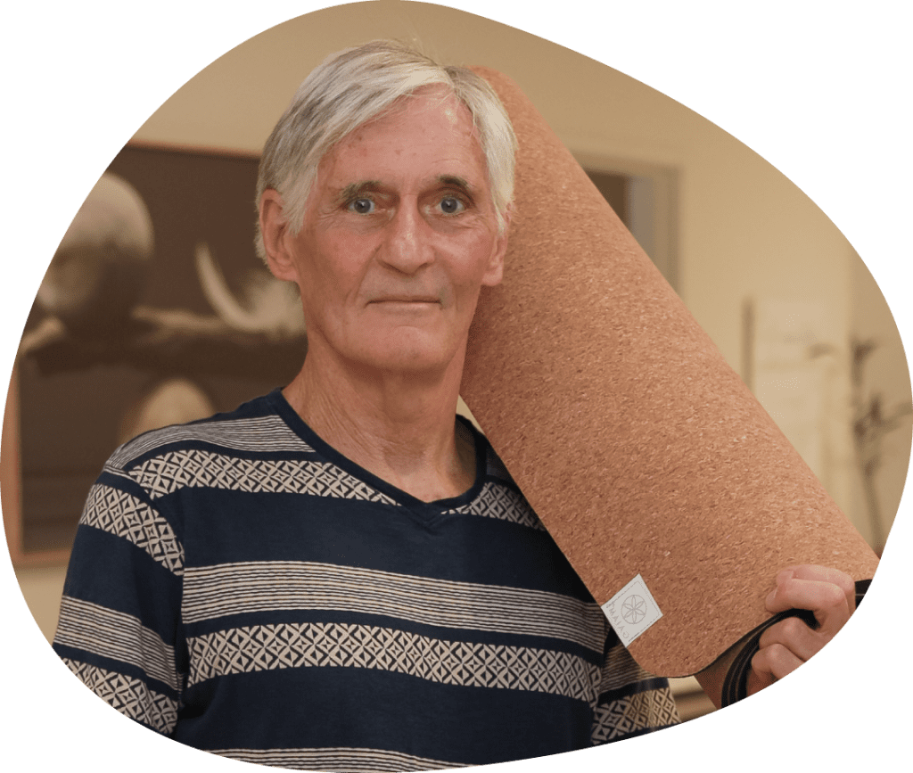 A man holding a cork board in his hands.